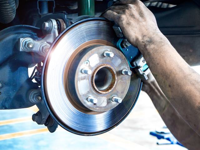 A technician fitting a new brake disc to the hub